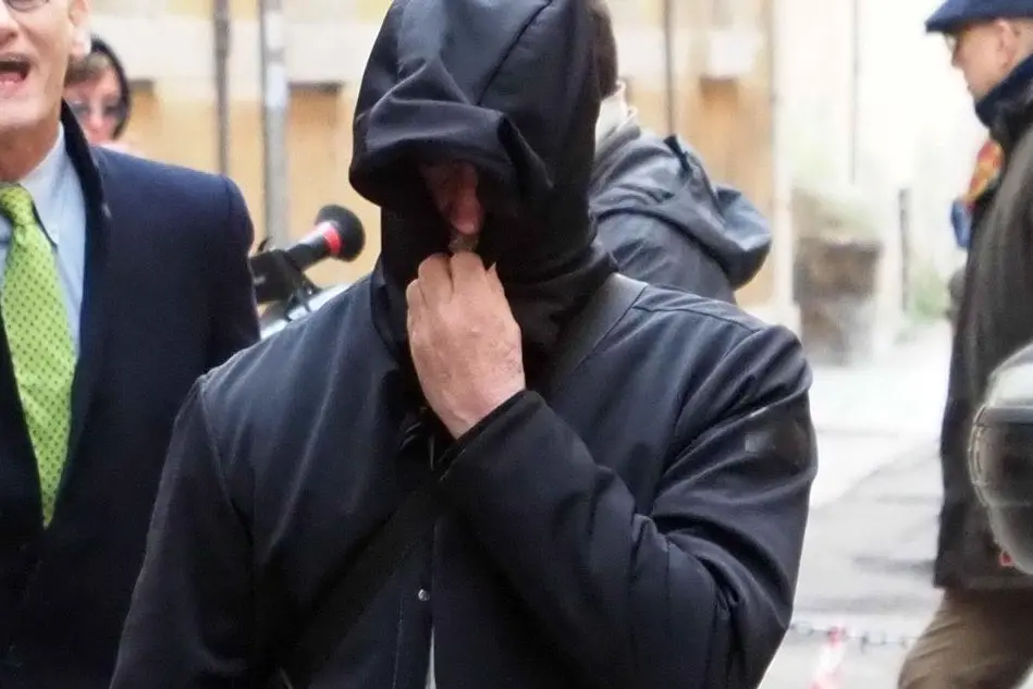 Gilberto Cavallini esce a volto coperto dal tribunale di Bologna (Ansa)