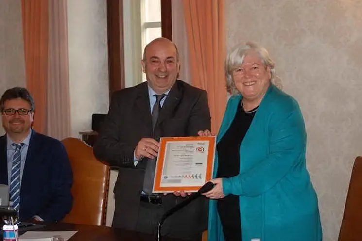 Giovanni Scotti consegna il premio alla rettrice Maria Del Zompo