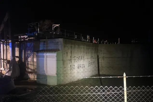 Il depuratore di Torpè dov'è stato fatto esplodere l'ordigno e le scritte contro il deposito di gas (Foto Ungredda)
