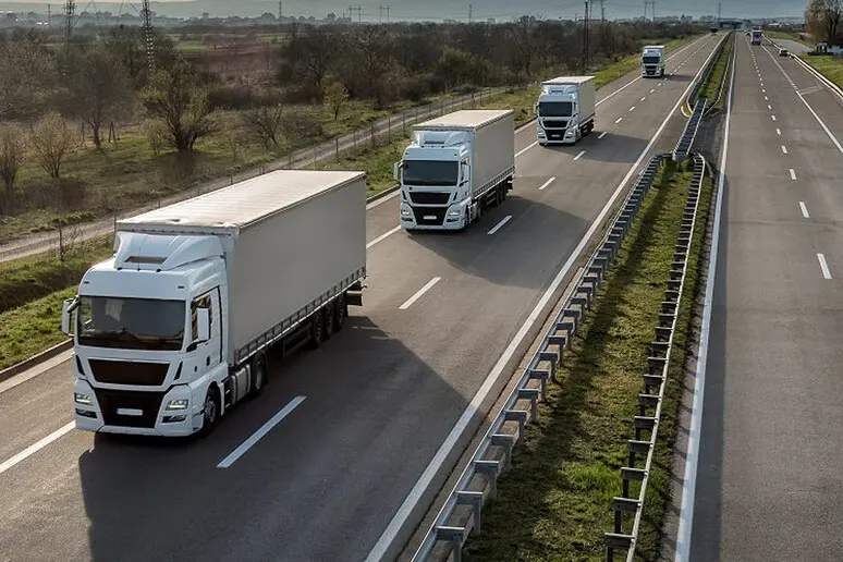 Una serie di Tir in autostrada (Ansa)