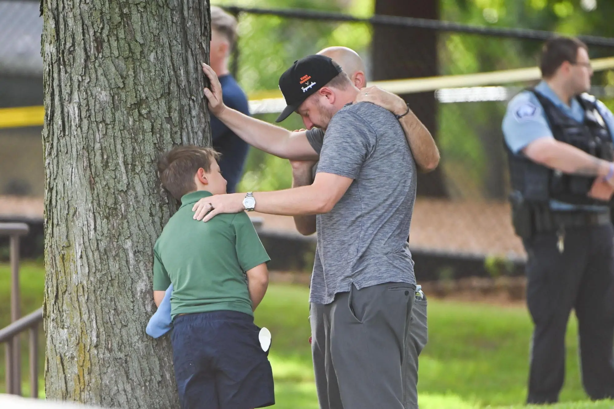 epa12327177 An adult and child take a moment while they leave the school as police respond to a shooting at the Annunciation Catholic School in Minneapolis, Minnesota, USA, 27 August 2025. According to police, two children and the gunman died and several were injured in the shooting at a Catholic primary church. EPA/CRAIG LASSIG