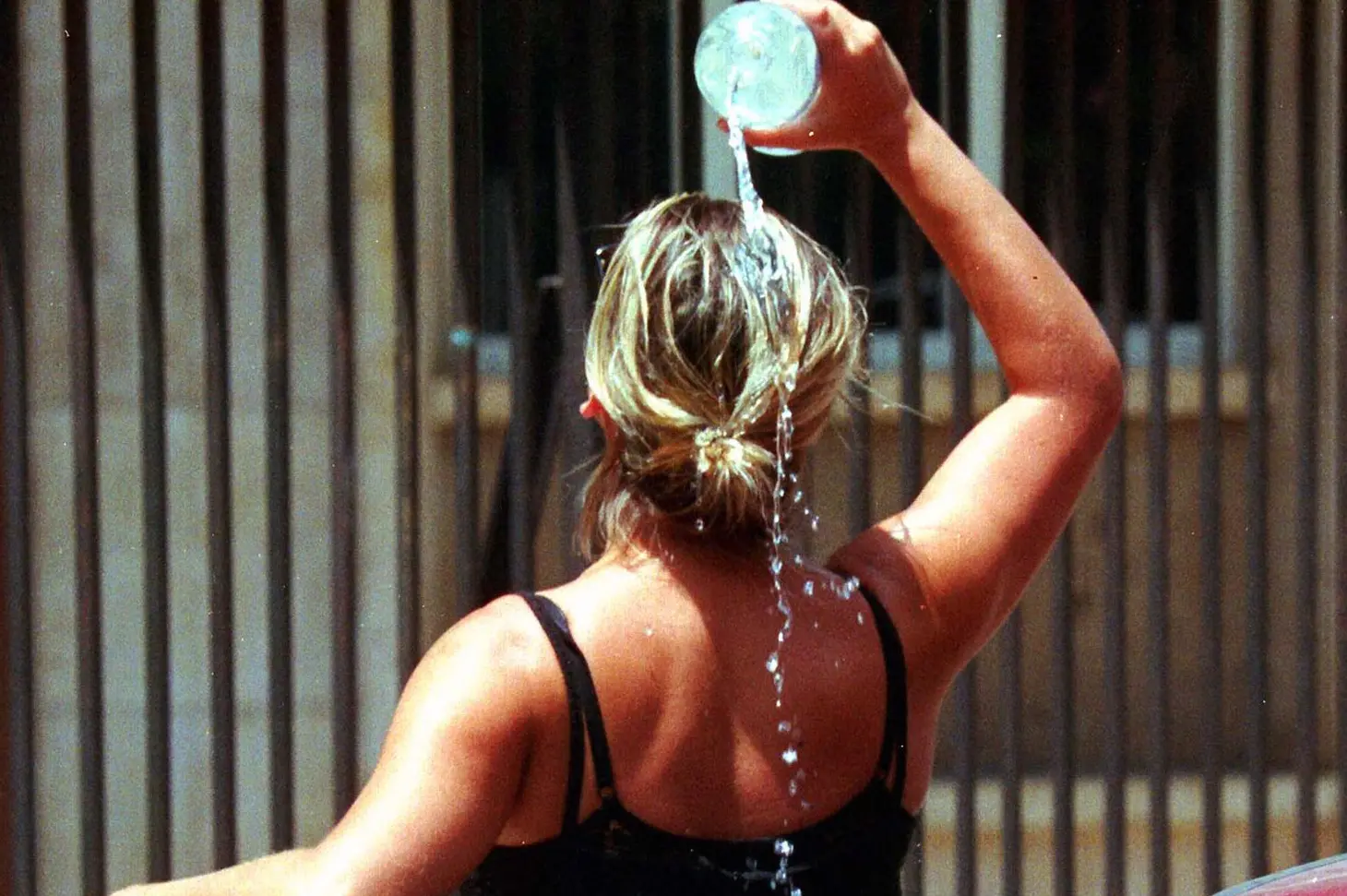 Una donna si rinfresca con una bottiglia d'acqua