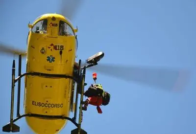 Un elicottero in azione col verricello che preleva una barella con assistente medico (L'Unione Sarda)