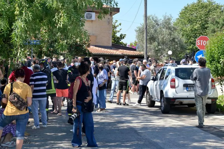 Stampa e curiosi davanti alla casa dove si barricato l'uomo che ha sparato e ucciso due bambini e un\u00A0anziano ad Ardea (Ansa)