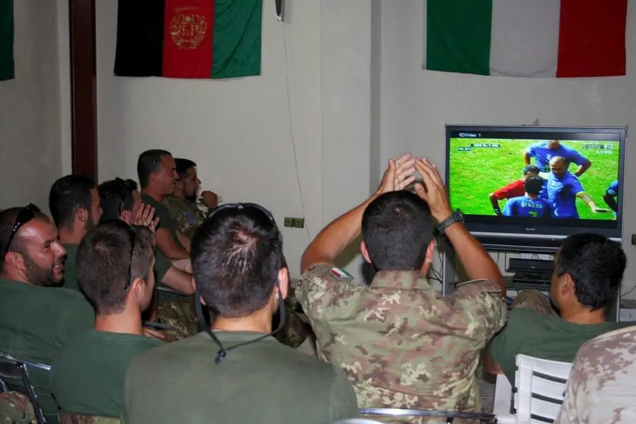Soldati italiani guardano una partita della Nazionale (Ansa)