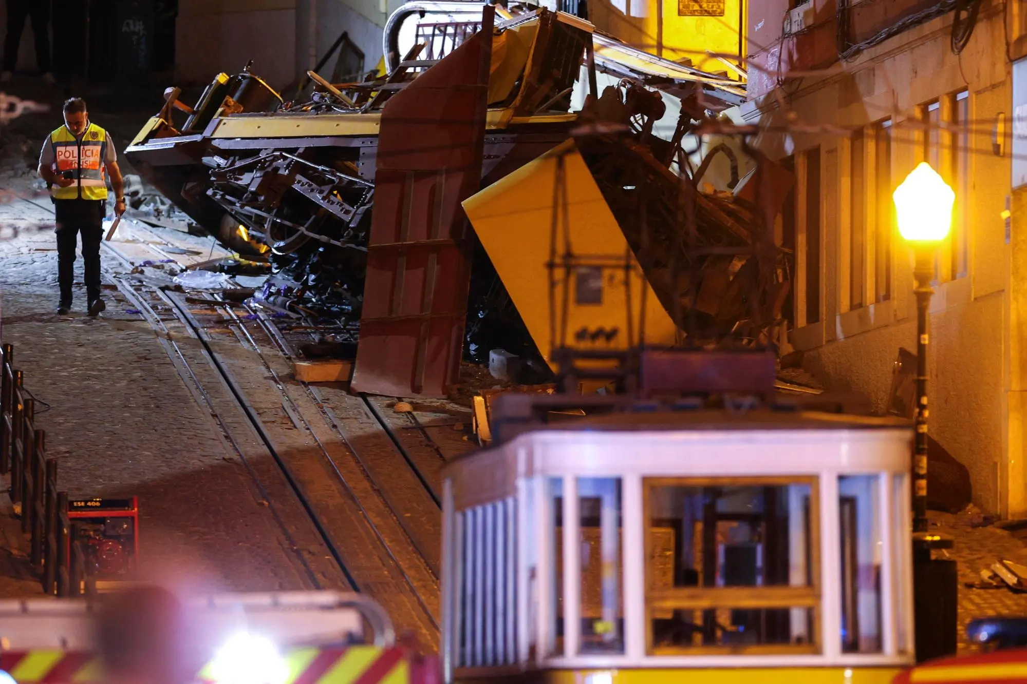 epaselect epa12350498 A police officer stand at the scene after the Gloria funicular cable railway derailed in Lisbon, Portugal, 03 September 2025. At least 15 people died in the derailment and 18 others were injured, local emergency services reported. EPA/MIGUEL A. LOPES