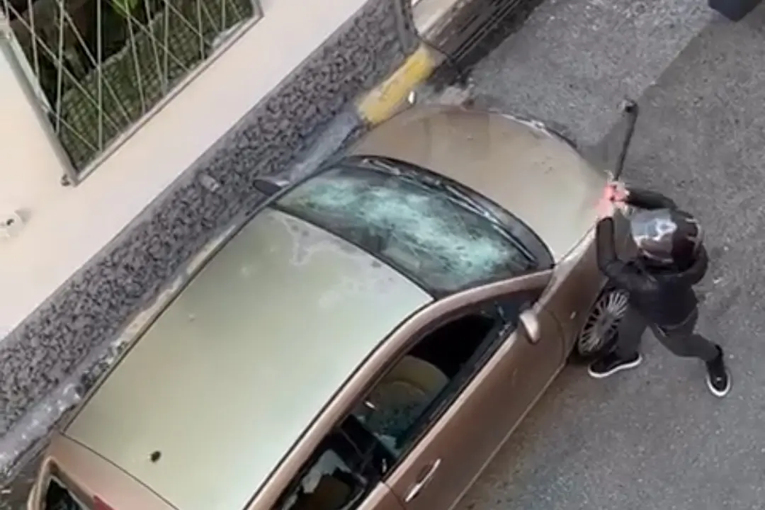 Un frame del video in cui l'uomo distrugge l'auto della ex