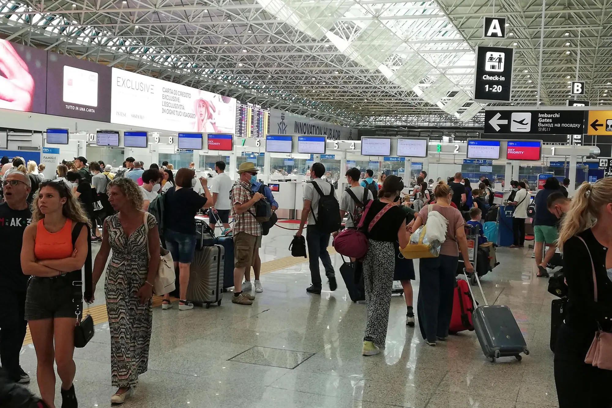 Turisti in fila nei terminal in attesa di imbarcarsi (Ansa)