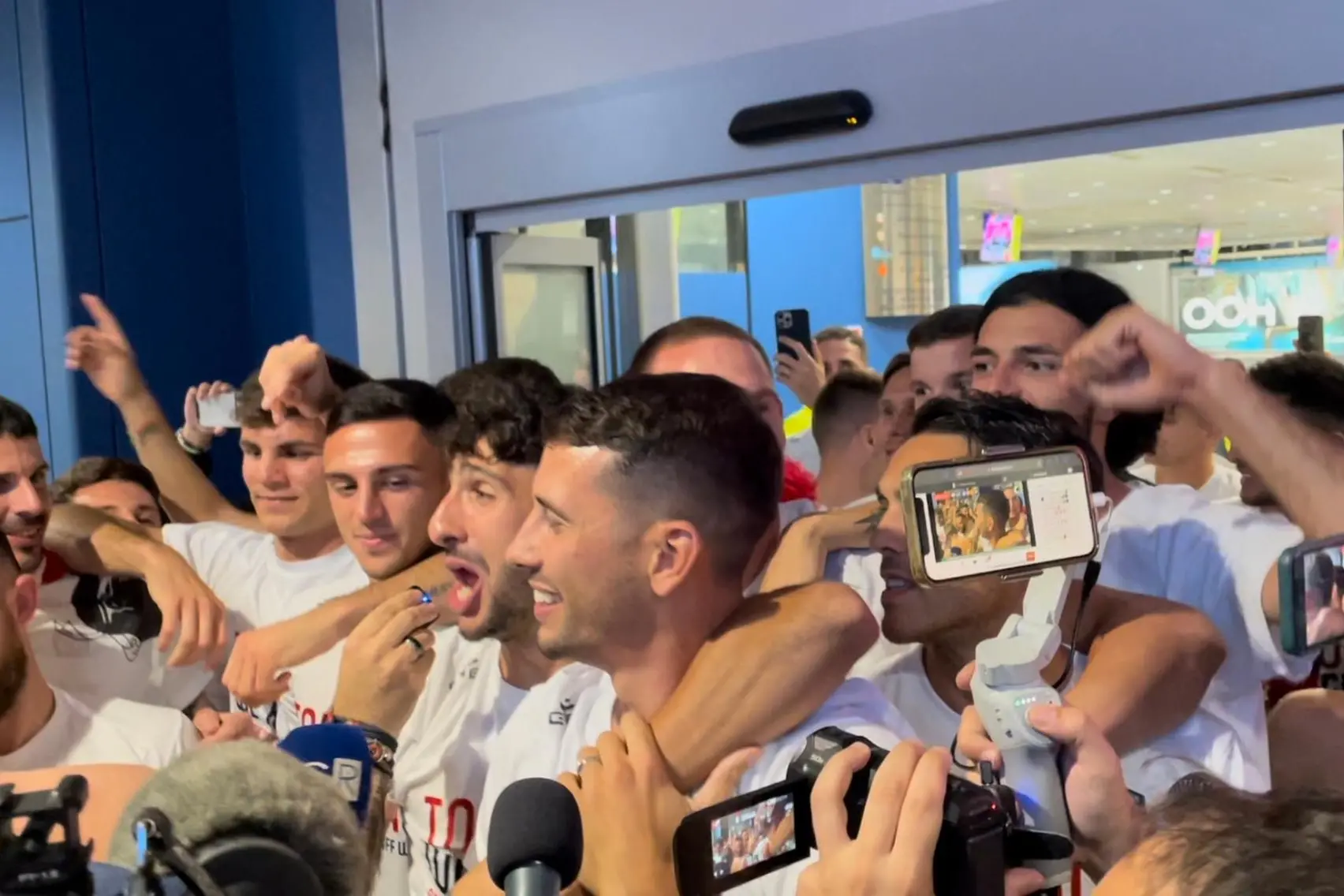 La festa del Cagliari coi tifosi in aeroporto (foto Spignesi)