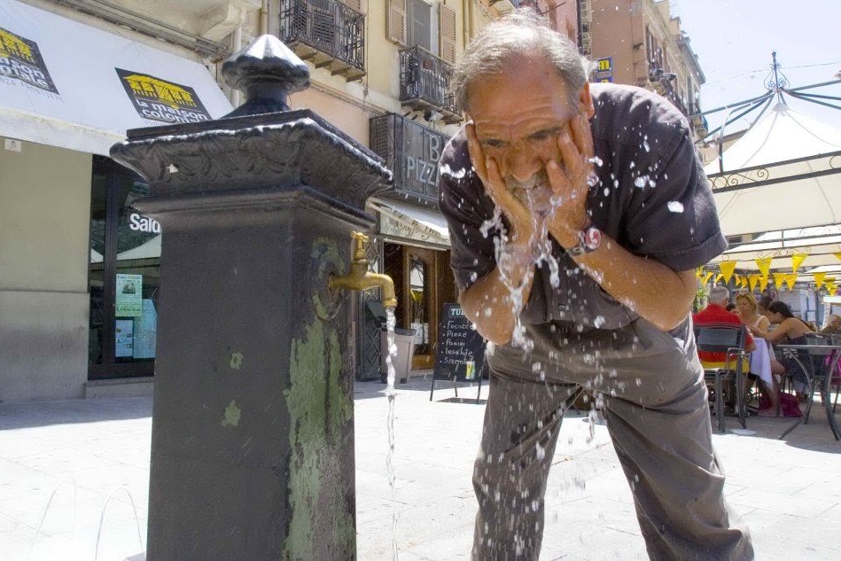 Un uomo si rinfresca a una fontanella (Archivio L'Unione Sarda)
