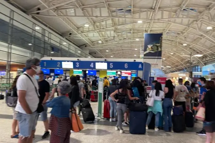 Turisti in fila con mascherina aeroporto Cagliari-Elmas