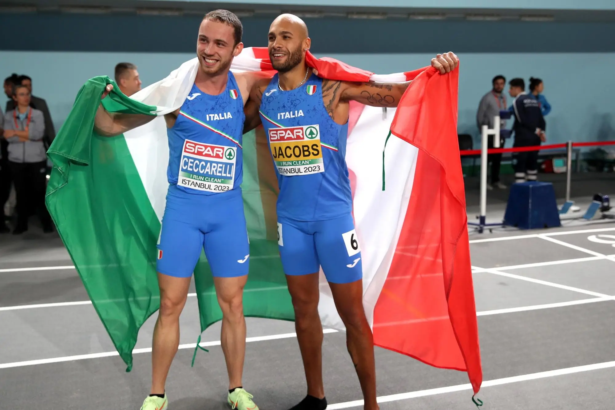 Ceccarelli e Jacobs all'arrivo con la bandiera italiana (Foto Ansa)