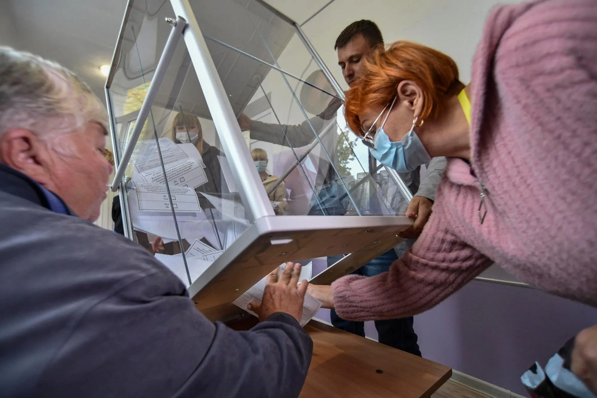 epa10209602 Local election commission members pull out ballots for vote counting in a so-called 'referendum' on the joining of Russian-controlled regions of Ukraine to Russia, at a polling station in Melitopol, Zaporizhzhia region, southeastern Ukraine, 27 September 2022. From 23 to 27 September, residents of the self-proclaimed Luhansk and Donetsk People's Republics as well as the Russian-controlled areas of the Kherson and Zaporizhzhia regions of Ukraine voted on a so-called 'referendum' to join the Russian Federation. On 24 February 2022 Russian troops entered the Ukrainian territory in what the Russian president declared a 'Special Military Operation', starting an armed conflict that has provoked destruction and a humanitarian crisis. EPA/STRINGER