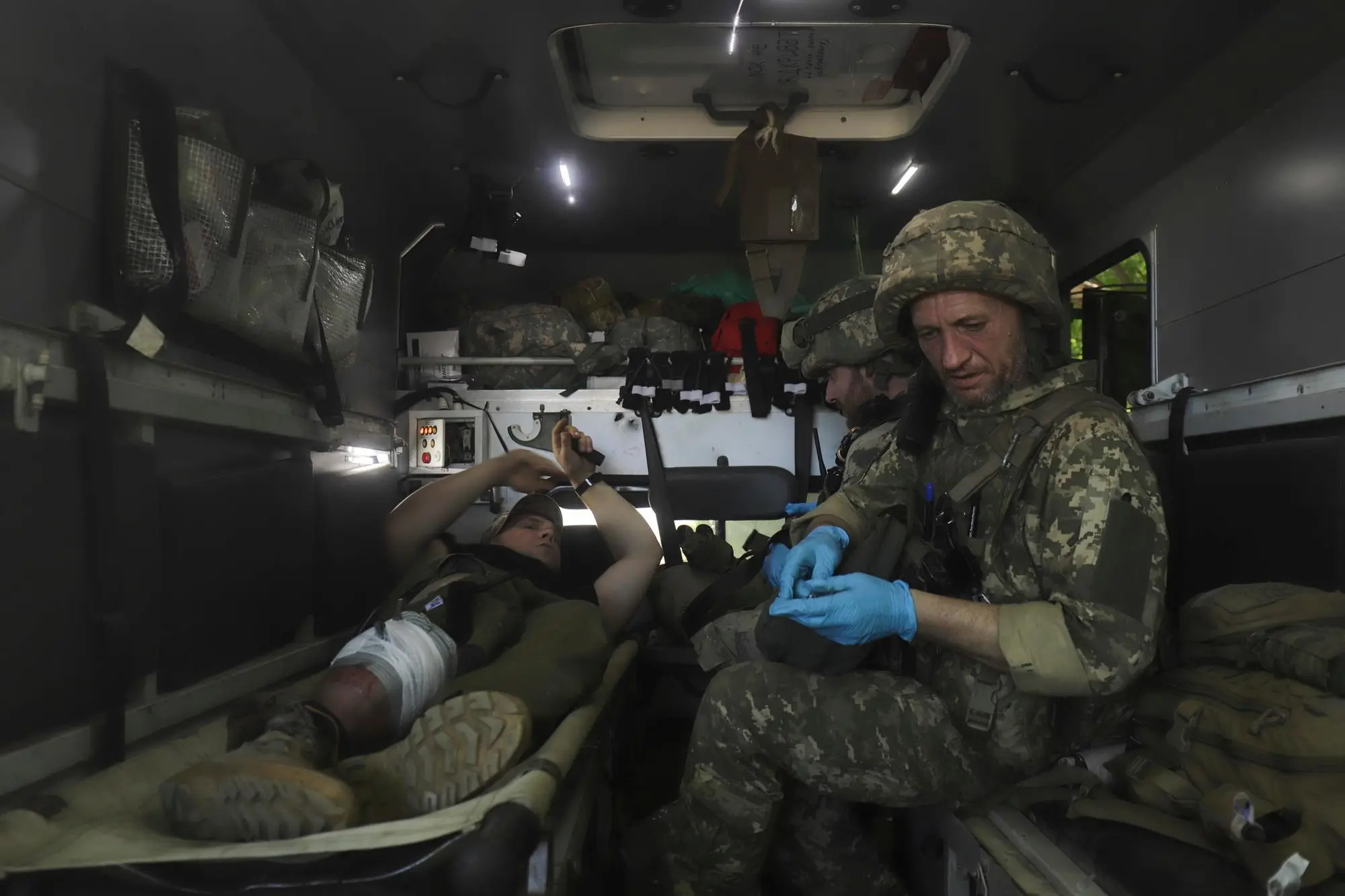 epa10006872 A military medic gives first aid to an injured Ukrainian serviceman close to a front line near the small city of Svitlodarsk of Donetsk area, 10 June 2022 amid heavy fighting in that region in the last days. Russian troops entered Ukrainian territory on 24 February causing fighting and destruction and a humanitarian crisis. According to the UNHCR, more than 6.9 million refugees have fled Ukraine, and a further 7.7 million people have been displaced internally within Ukraine since. EPA/STR