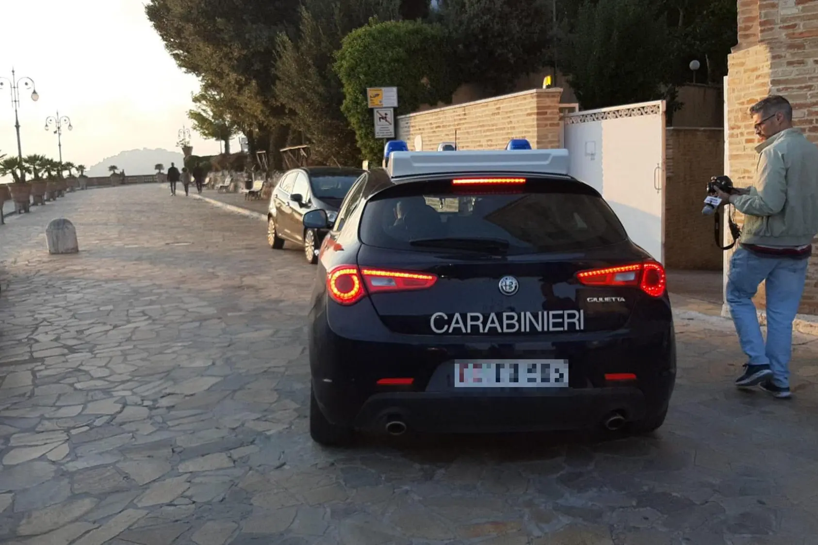 L'auto dei Carabinieri che porta in caserma il sospettato per l'interrogatorio (foto Ansa)