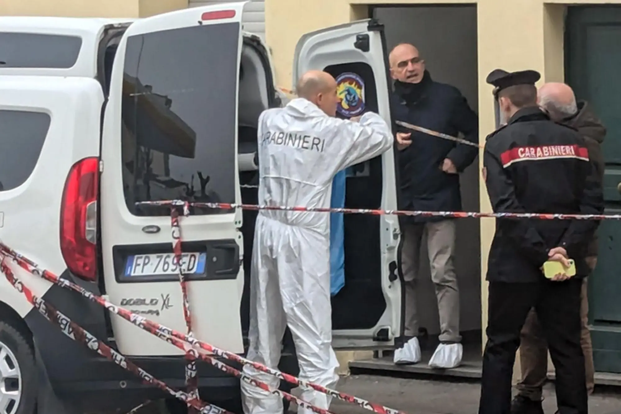 Inquirenti all'esterno dell'abitazione dove è stato commesso l'omicidio (Ansa)