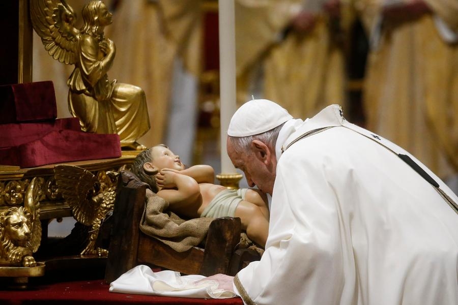Pope Francis kisses a figurine of baby Jesus during the Christmas Holy Mass in Saint Peter's Basilica at the Vatican, 24 December 2021. ANSA/FABIO FRUSTACI