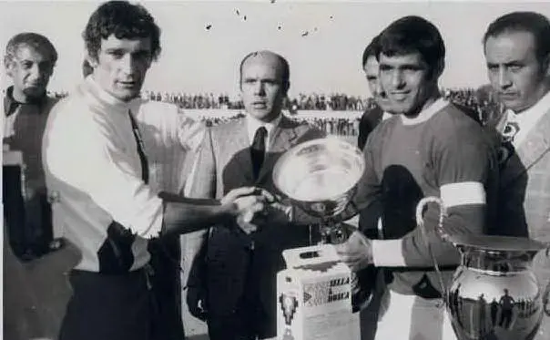 Alghero, dicembre 1971, il capitano dell'Alghero Gino Di Napoli stringe la mano a Gigi Riva. Al centro Pino Giorico, a sinistra Manlio Scopigno (foto concessa da Tommaso Di Napoli)