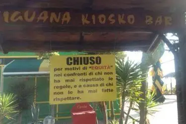 Un cartello avvisa i clienti della chiusura nel bar 'Iguana', al Poetto