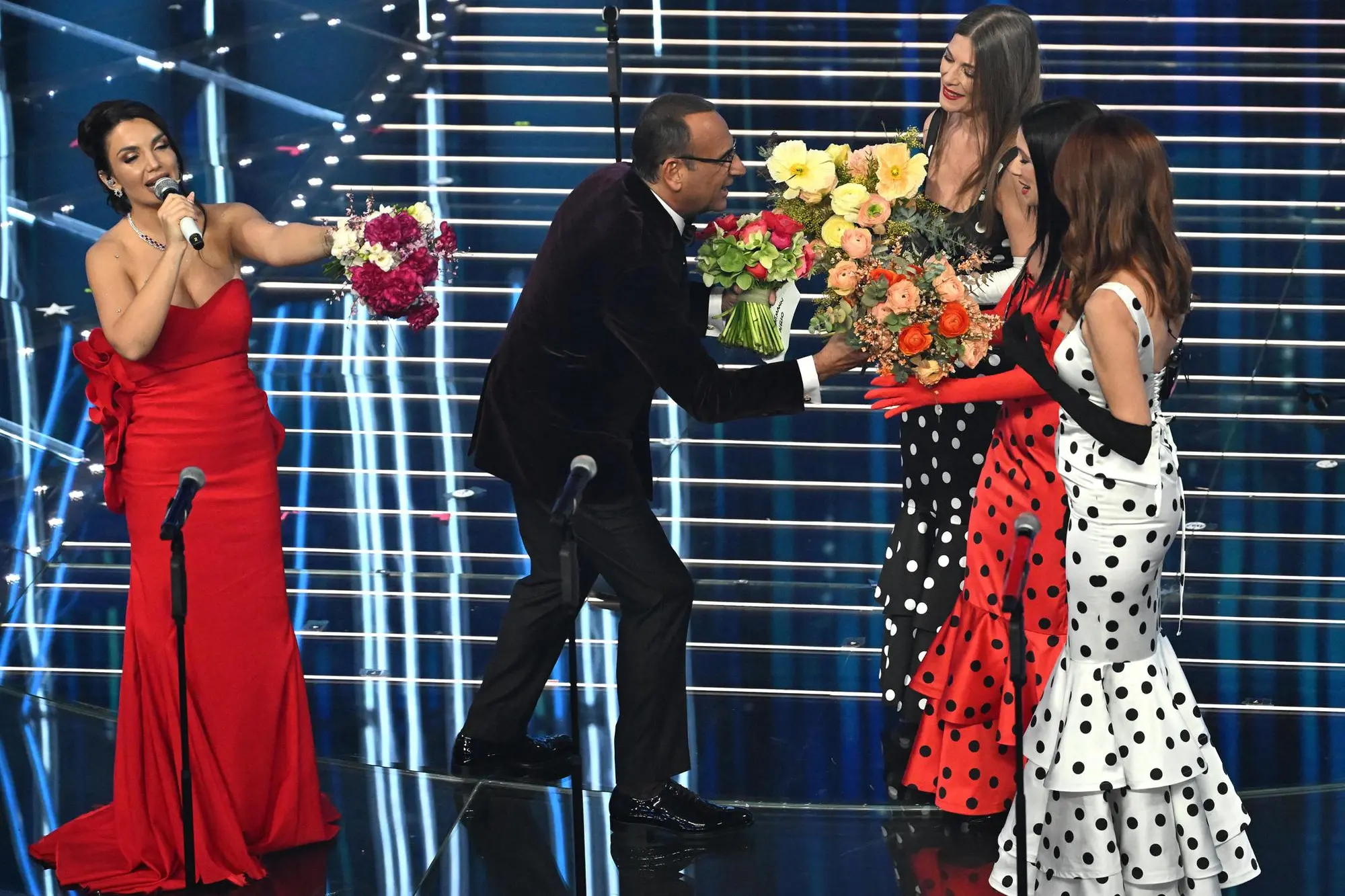 Italian singer Elettra Lamborghini, Sanremo Festival host and artistic director Carlo Conti and Spanish group Las Ketchup on stage at the Ariston theatre during the 76th edition of the Sanremo Italian Song Festival, in Sanremo, Italy, 27 February 2026. The music festival will run from 24 to 28 February 2026. ANSA/RICCARDO ANTIMIANI