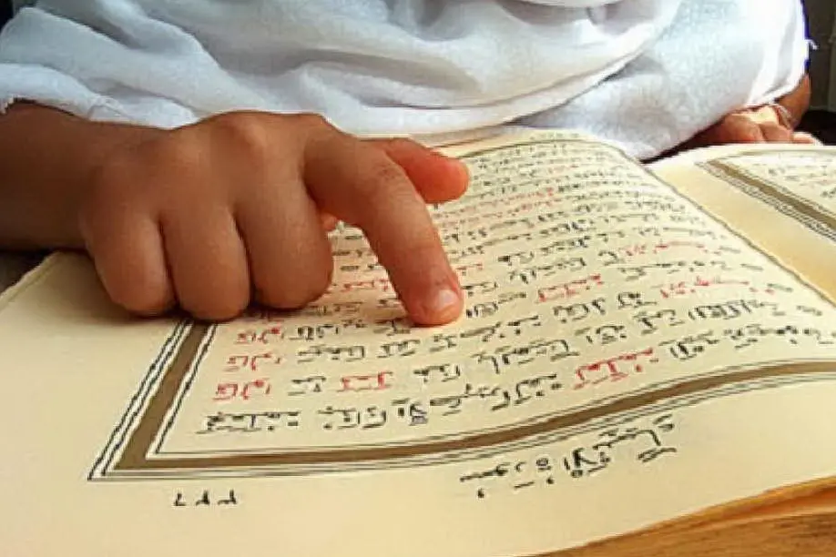 Un bambino legge il Corano
