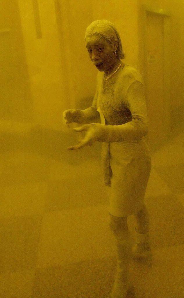 Una donna coperta dalla polvere a seguito del crollo degli edifici