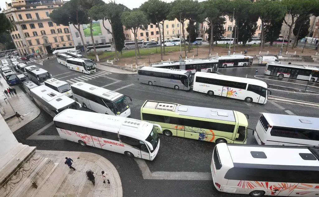 I bus parcheggiati a decine in piazza Venezia (Ansa)