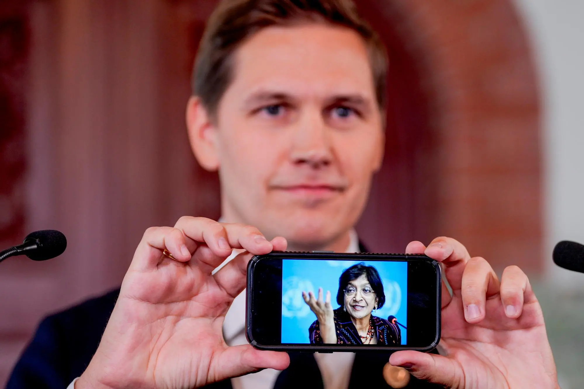 Il presidente del Comitato norvegese per il Nobel mostra sul proprio telefono una foto di Pillay (foto Ansa/Epa)