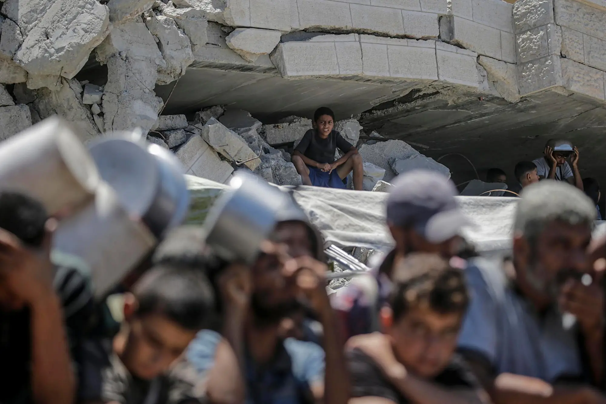 Palestinesi si radunano per ricevere cibo da una mensa di beneficenza, a Gaza City (Ansa)