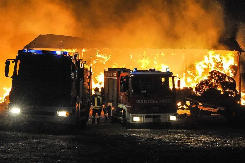 I Vigili del fuoco davanti al fienile in fiamme (foto L'Unione Sarda - Cucca)