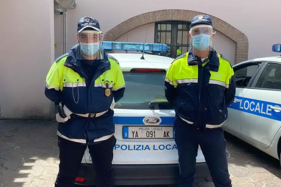 Due agenti indossano i caschi donati dai volontari