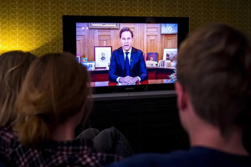 Famiglia olandese guarda il discorso di Rutte in tv (Ansa)