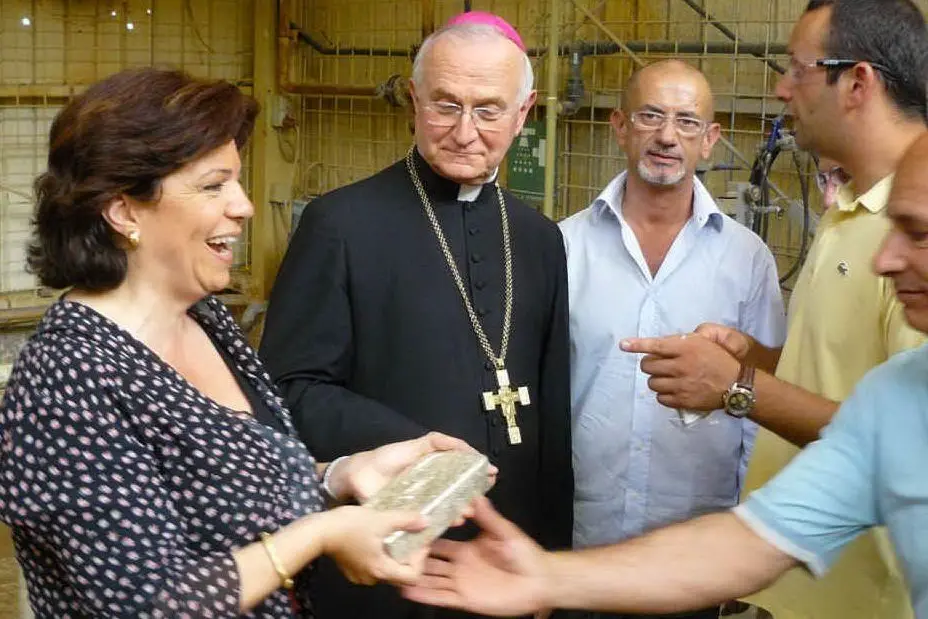 Maria Lucia Baire, direttore del Museo del Duomo di Cagliari Castello e mons. Giuseppe Mani, arcivescovo cagliaritano, consegnano il lingotto d'oro donato dai minatori di Furtei