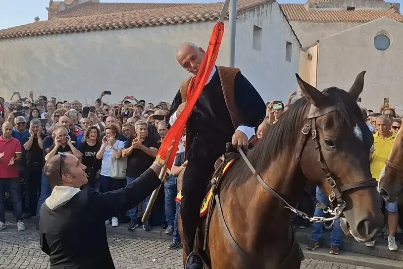 Don Maurizio Demartis consegna una bandiera per l'Ardia 2025 (foto Corrias)