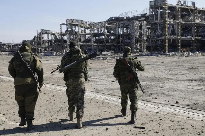 epa04976303 Pro-Russian rebels walk in front of the destroyed International Airport building in Donetsk, 13 October 2015 where heavy fighting were go on more 240 days till January 2015. The Dutch Safety Board was to present its final report into the downing of Malaysia Airlines flight MH17 over eastern Ukraine last year. MH17 was on its way from Amsterdam to Kuala Lumpur when it went down in rebel-controlled territory on 17 July 2014, killing all 298 people on board. EPA/ALEXANDER ERMOCHENKO