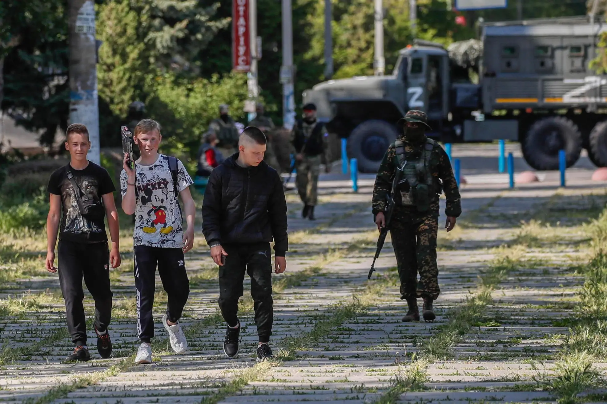 A picture taken during a media tour organized by the Russian Army shows local youths walking past a Russian serviceman in Skadovsk, Kherson region, Ukraine, 20 May 2022 (issued 21 May 2022). The Russian-appointed head of Ukraine's Kherson region, Volodymyr Saldo, said that the area will 'soon become part of the Russian Federation'. The governor was installed by Russian forces after they took control of the southern Ukrainian region in March 2022. ANSA/SERGEI ILNITSKY