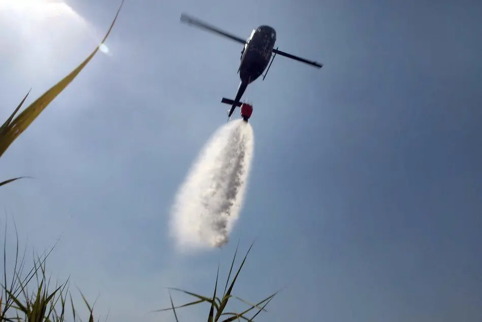 Un elicottero impegnato nello spegnimento di un incendio (Archivio L'Unione Sarda)