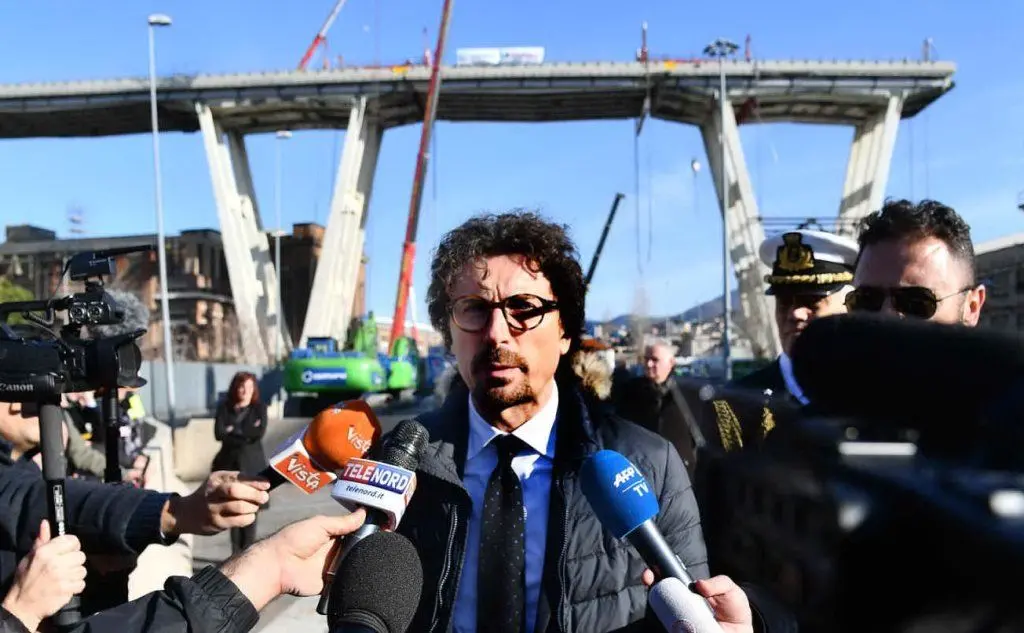 Toninelli intervistato sotto il ponte Morandi (Ansa)
