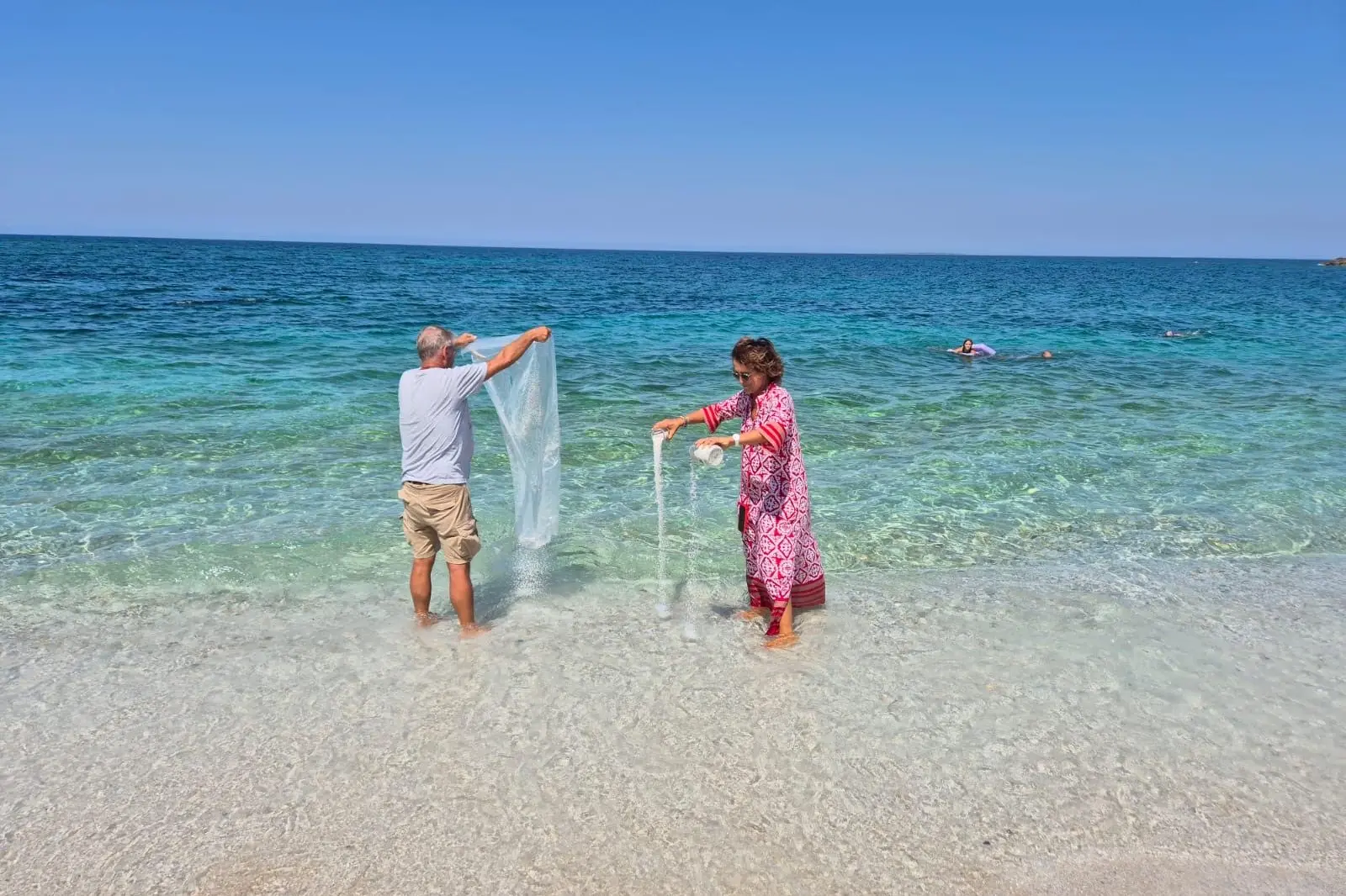 Silvia Ferrari assieme al marito mentre restituisce la sabbia al mare (foto concessa)