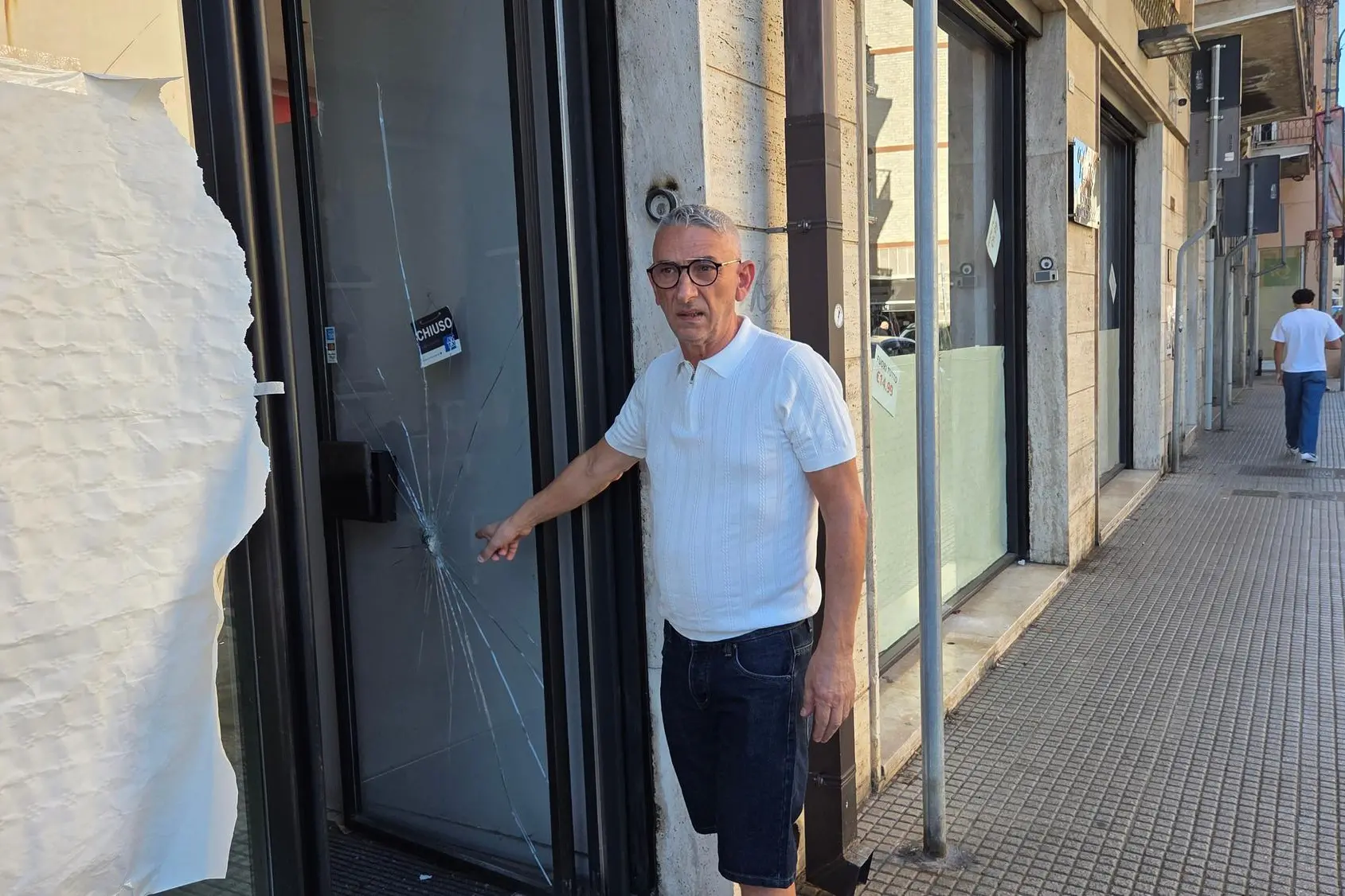 Salvatore Ferrara davanti alla vetrata danneggiata (g. da.)
