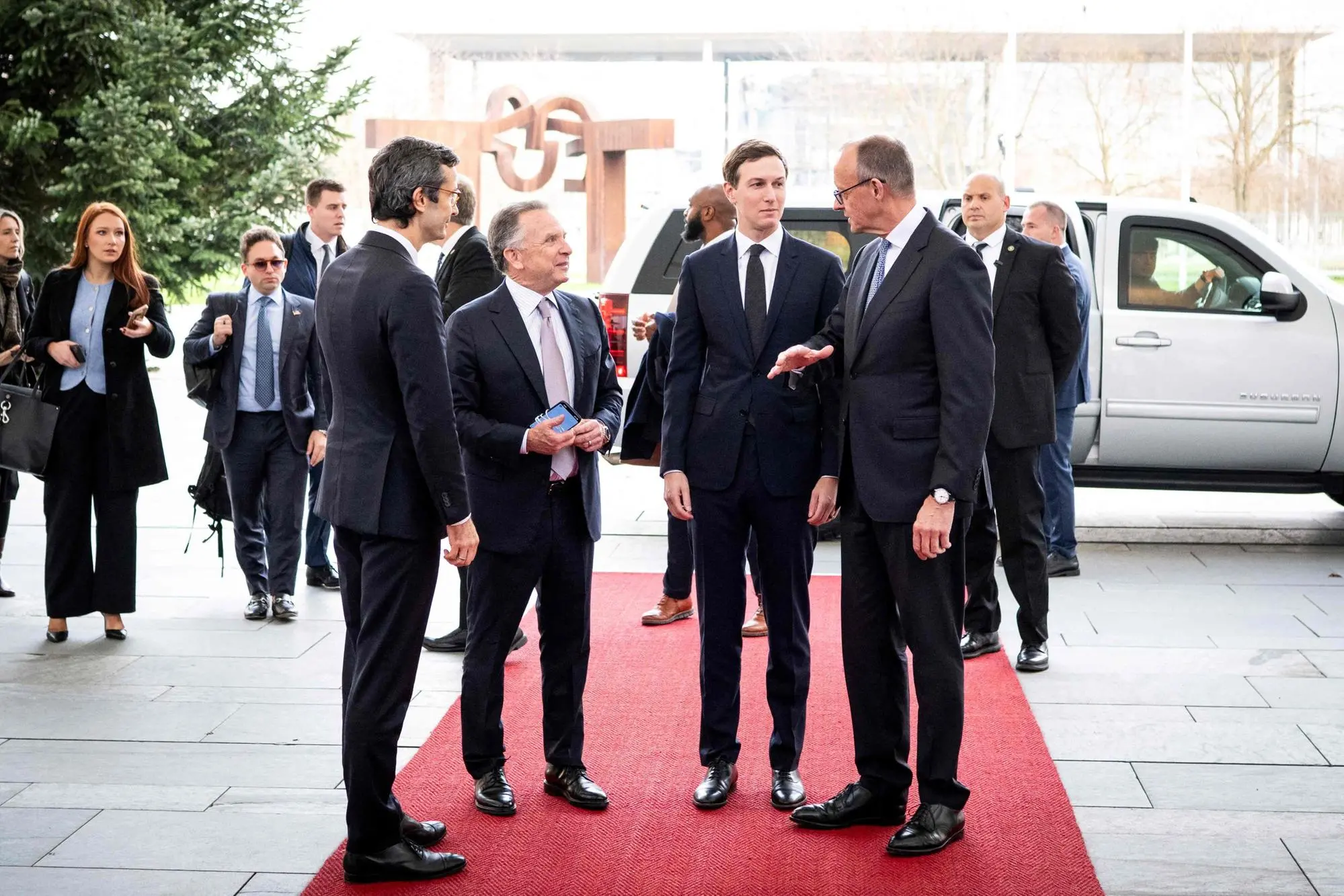 This handout photo released on December 14, 2025 by the German government's press service shows German Chancellor Friedrich Merz (R) greeting US special envoy Steve Witkoff (2ndL) and US President Donald Trump's son-in-law Jared Kushner (2ndR) prior to a meeting in the courtyard of the Chancellery in Berlin, on December 14, 2025. Ukrainian President Volodymyr Zelensky traveled to Berlin to meet European leaders as well as the heads of the EU and NATO, German government spokesman Stefan Kornelius said. (Photo by Guido Bergmann / Presse- und Informationsamt der Bundesregierung / AFP) / RESTRICTED TO EDITORIAL USE - MANDATORY CREDIT "AFP PHOTO/ HO/ Presse- und Informationsamt der Bundesregierung- NO MARKETING NO ADVERTISING CAMPAIGNS - DISTRIBUTED AS A SERVICE TO CLIENTS - NO ARCHIVE