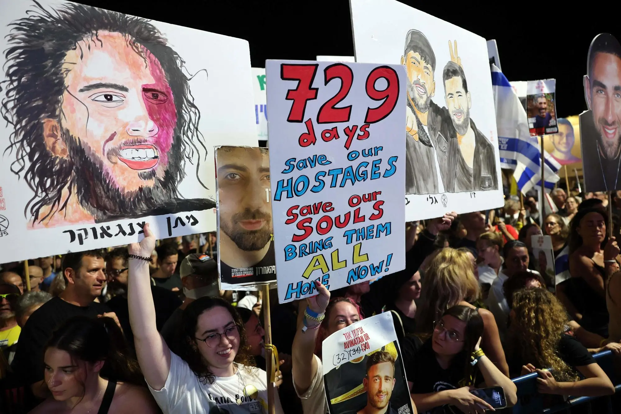 People raise placards and pictures of Israeli detainees during a rally organised by families of hostages held in the Gaza Strip since October 2023, in the plaza outside the Tel Aviv Museum of Art, known as the "Hostages' Square", in Tel Aviv on October 4, 2025. A senior Hamas official said on October 4 that Egypt would organise a conference for Palestinian factions to decide on the post-war future of the Gaza Strip, after the group accepted to release hostages under a US ceasefire plan. (Photo by Jack GUEZ / AFP)
