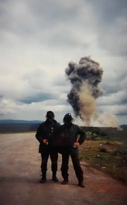 Due militari in posa con le maschere anti-gas a Quirra. Dietro una &quot;nube tossica&quot;