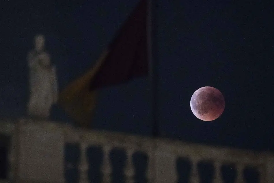 Luna rossa sul Campidoglio, Roma (Ansa)