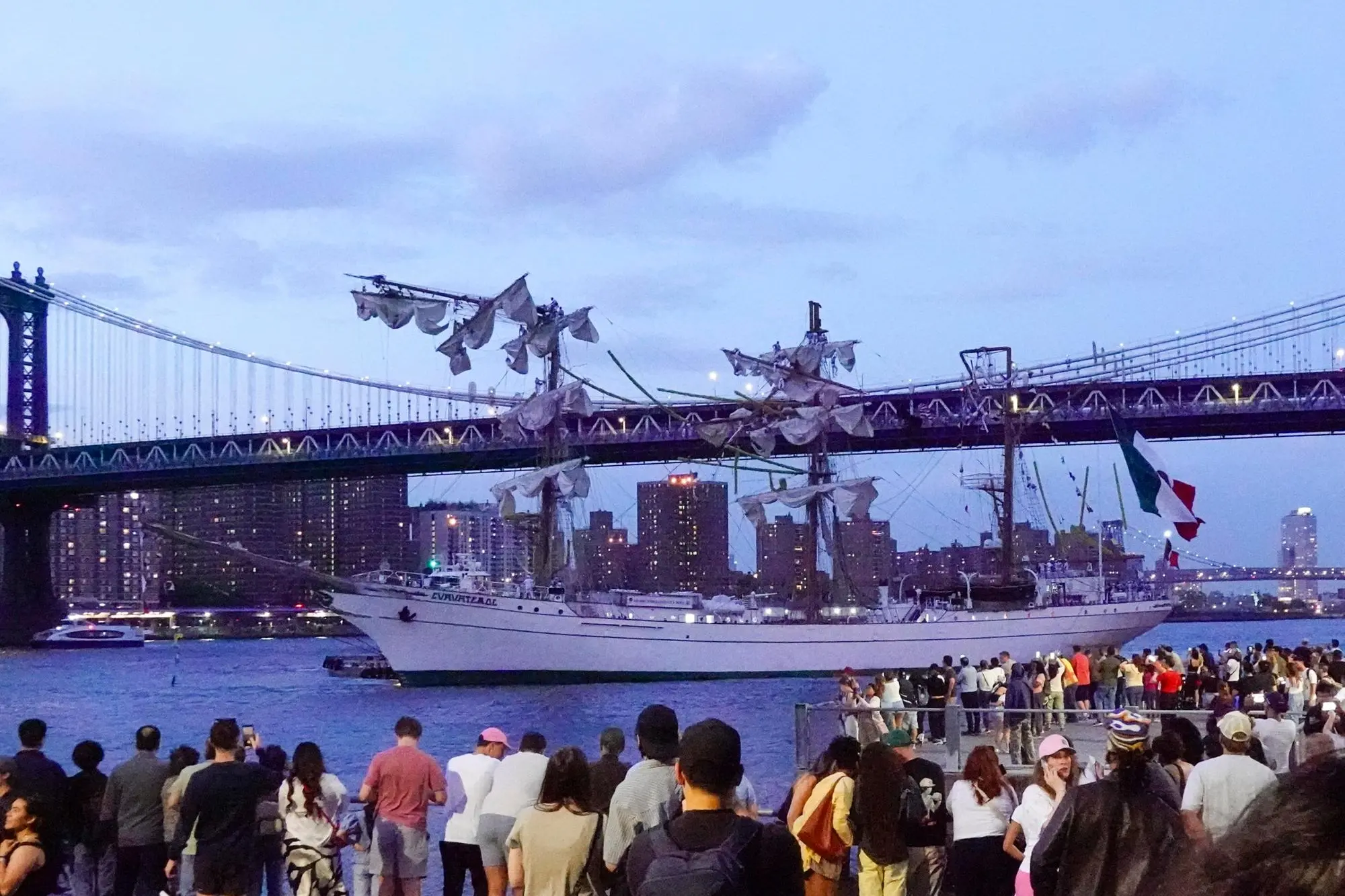 epaselect epa12111535 People look at the Cuauhtemoc, a Mexican Navy training boat, as it sits in the East River after the ship hit the Brooklyn Bridge, in New York, New York, USA, 17 May 2025. EPA/PORTER BINKS