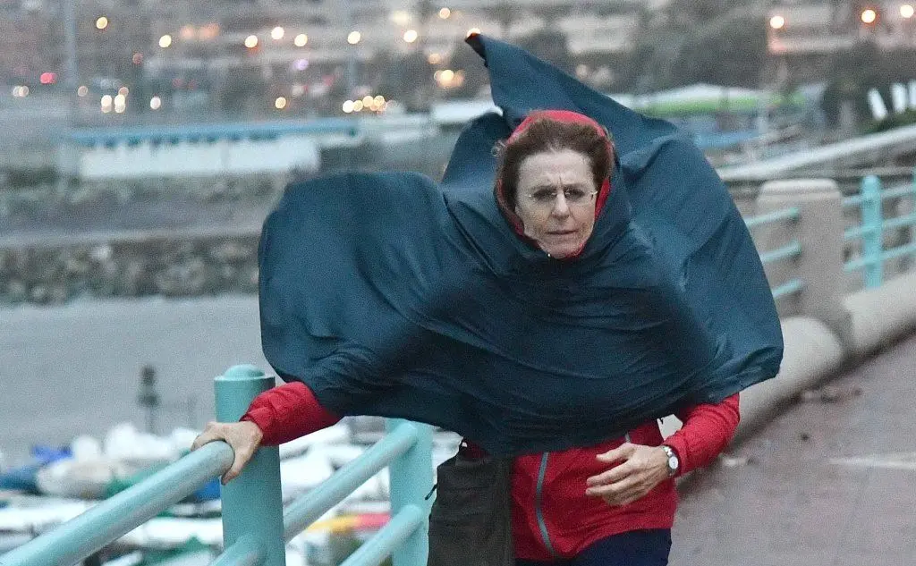 Una signora si tiene alle ringhiere di corso Italia a causa delle forti raffiche di vento, Genova