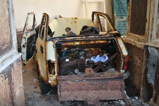 Una carcassa di auto all'interno dell'orfanotrofio Sacro Cuore (foto Pala)