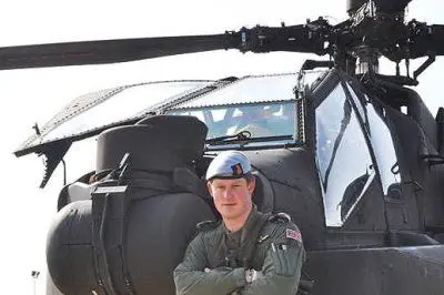 Il principe Harry davanti a un elicottero Apache
