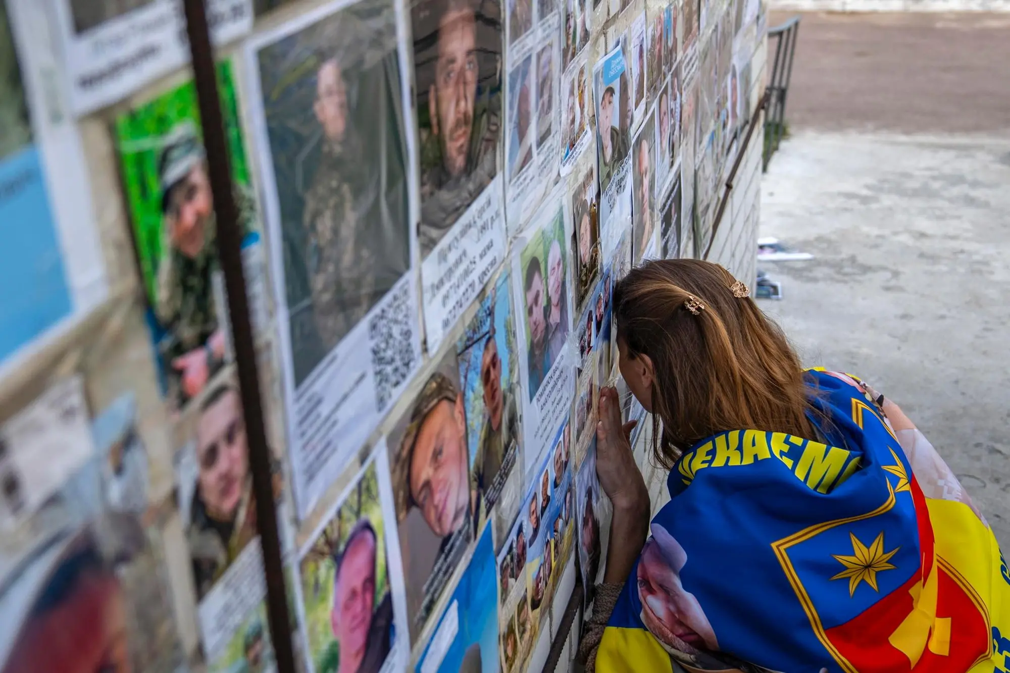 epa12320418 A Ukrainian woman reacts near portraits of missing people following a prisoner swap at an undisclosed location in Ukraine, 24 August 2025, amid the Russian invasion. Ukrainian officials said that 146 Ukrainian servicemen and civilians were returned in a prisoner exchange with Russia, including journalist Dmytro Khylyuk and former Mayor of Kherson Volodymyr Mykolayenko. EPA/STRINGER