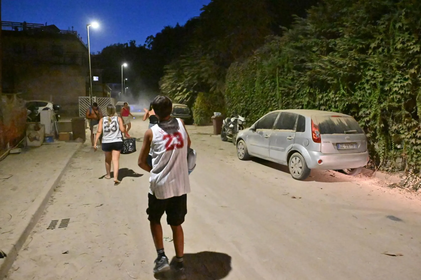 Un pezzo di montagna caduto e persone in strada in via Sottopasso Savino Vitagliano a Pozzuoli /Ansa (Felice De Martino)